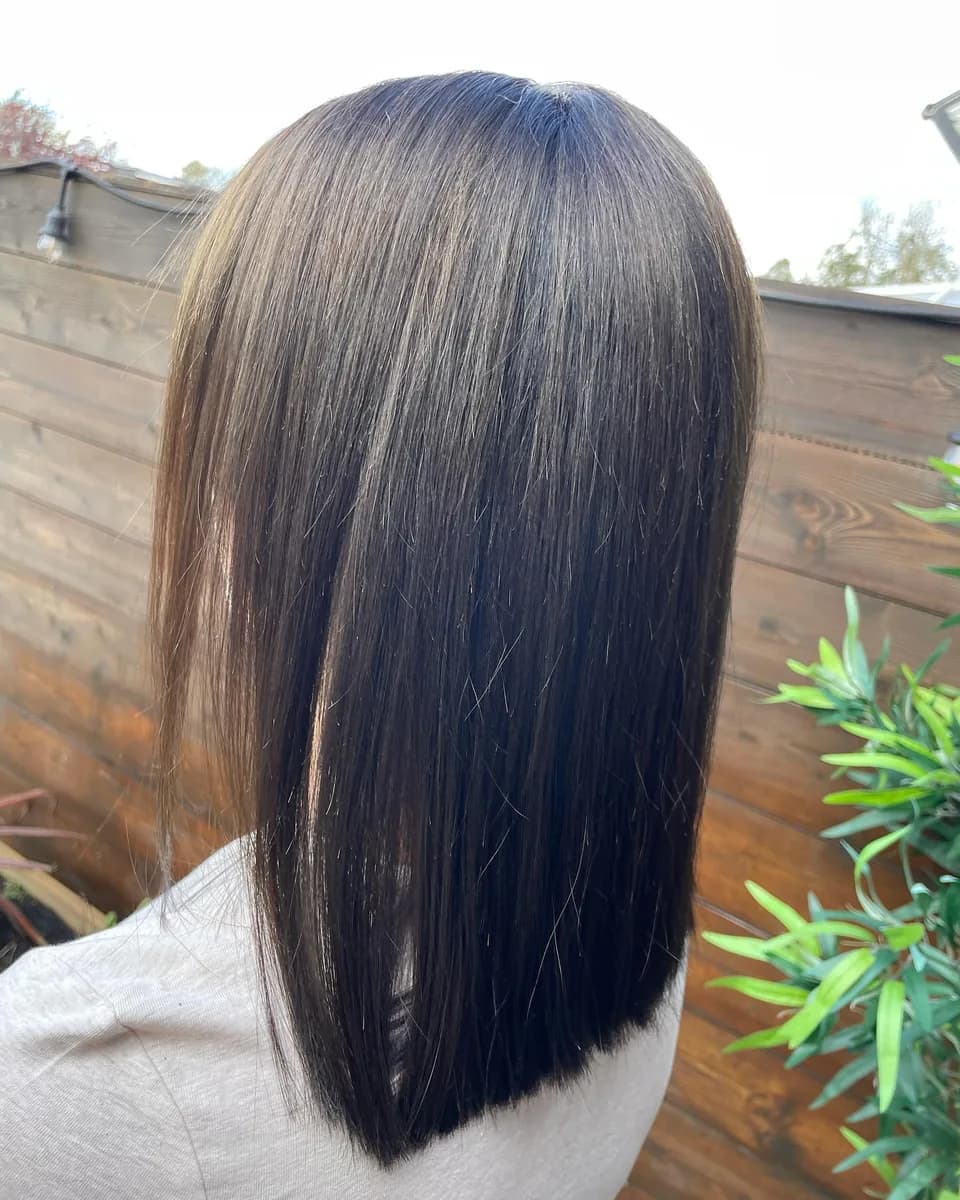 Near-black glossy hair, long and blow-dried straight